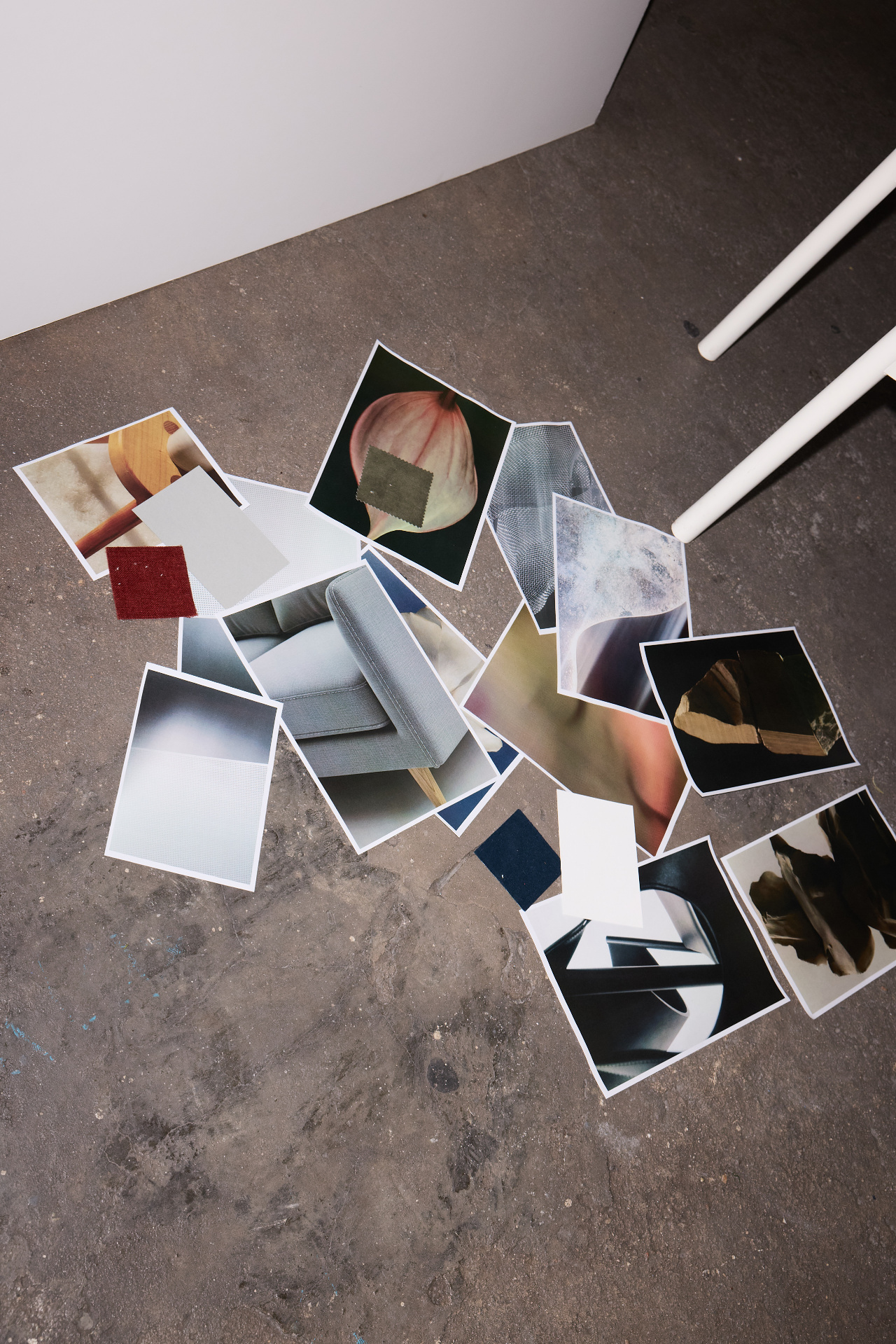 Printed references and material swatches arranged on a concrete floor