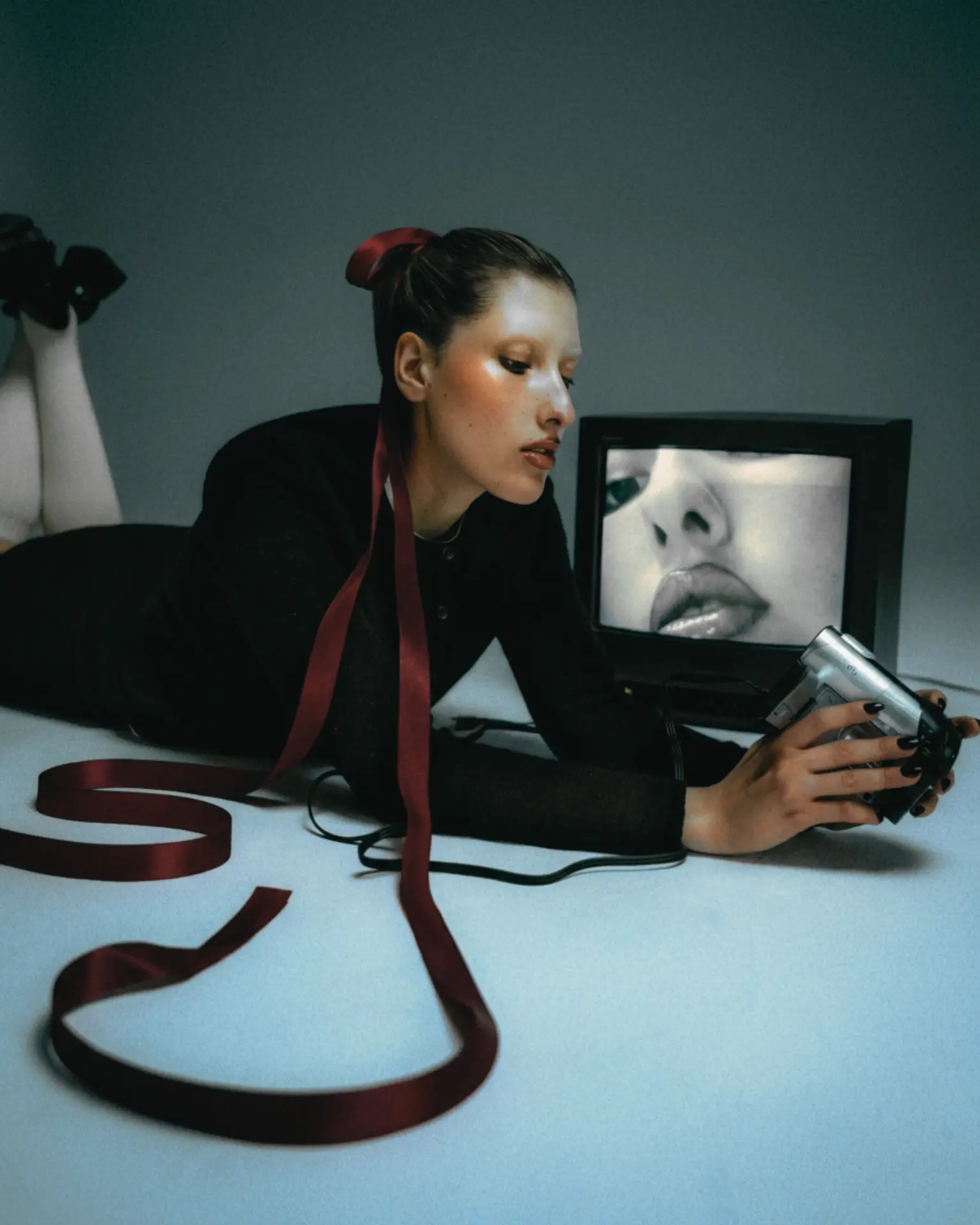 Editorial portrait with a length of deep red ribbon